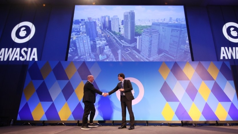 Microsoft Advertising Corporate Vice President, Rob Wilk, and Microsoft Japan CEO, Takuya Hirano, shake hands on the Advertising Week Asia 2022 mainstage. 