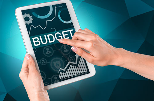 Two hands holding a tablet showing the word Budget.